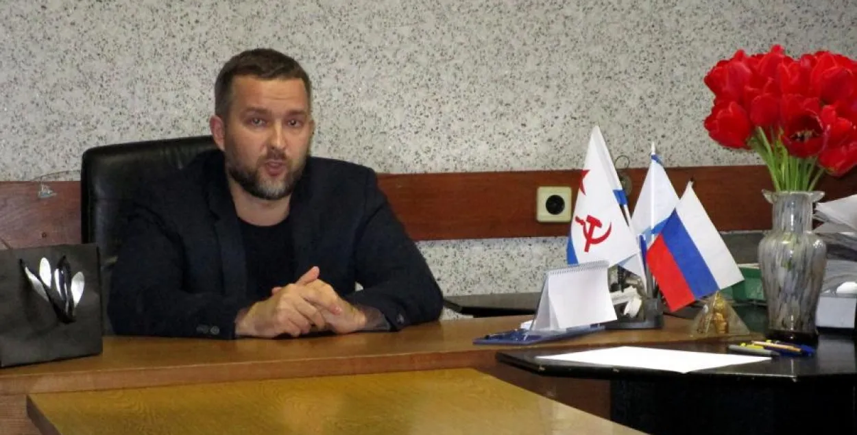 Сергей Черечень в Витебске за столом с российским флагом / vitebskspring.org