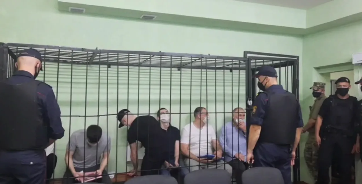 В клетке — Дмитрий Попов (не виден за милиционером), Владимир Цыганович, Артем Саков, Игорь Лосик, Сергей Тихановский, Николай Статкевич / кадр из видео Людмилы Гладкой