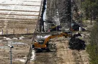 Экскаватары капаюць пясок каля памежнага плота з Расіяй / Reuters
