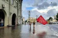 У суботу, 28 жніўня, двое мужчын шпацыравалі ў раёне Кастрычніцкай плошчы з rрасным сцягам / Euroradio