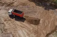 Грузовой автомобиль ссыпает песок