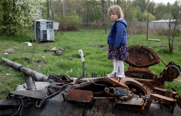 Дзіця на падбітым расійскім танку ў Кіеўскай вобласці / Reuters​