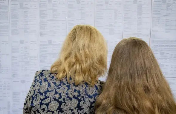 Сотрудницы БГУ возле расписания
