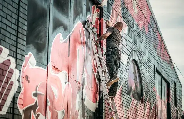 Мужчына, малюючы на сцене графіці
