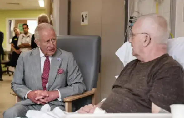 Карл III общается с больным в одной из британских клиник
