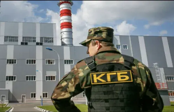 Сотрудник в форме КГБ на фоне одного из белорусских предприятий
